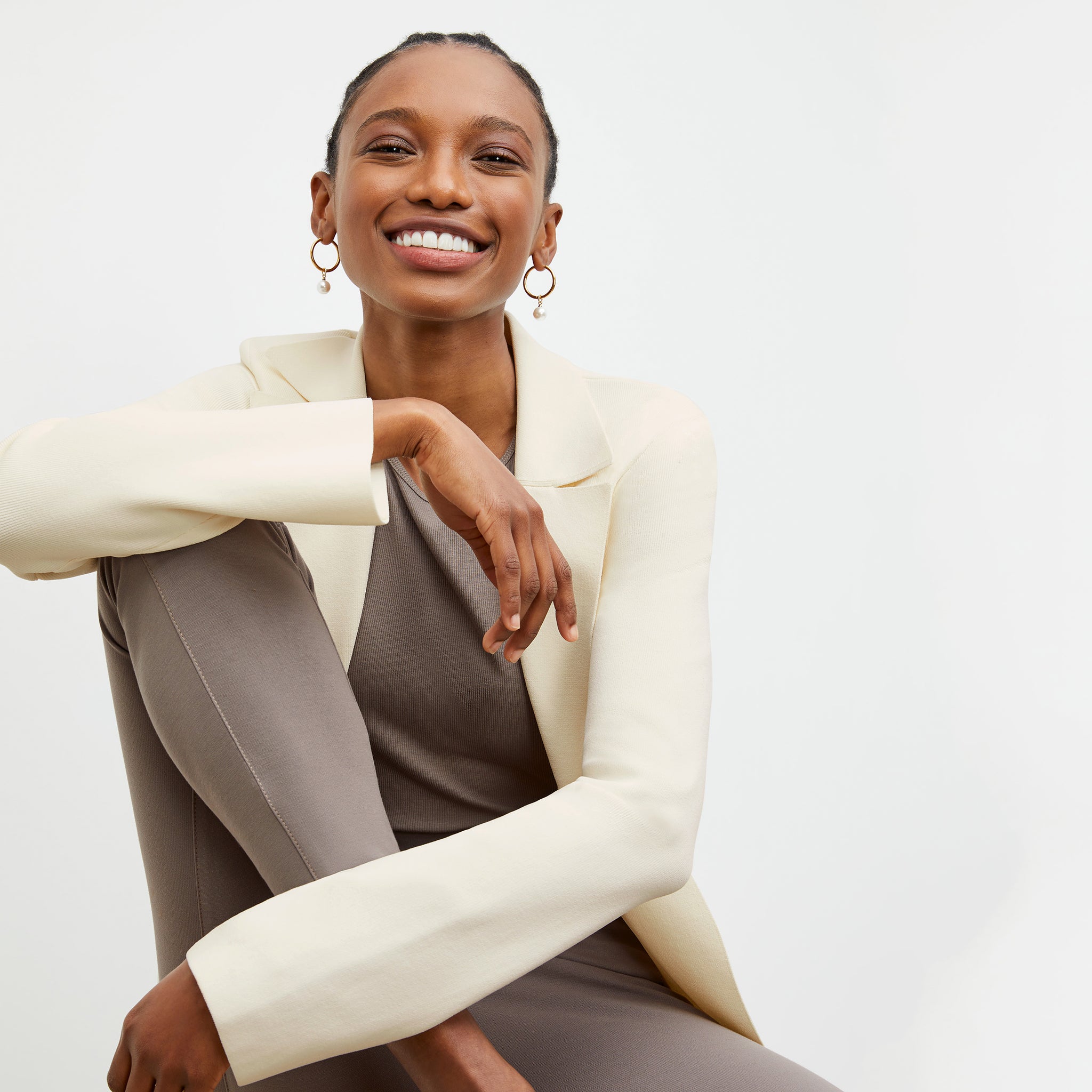 Front image of a woman standing wearing the Paige T-Shirt—Fine Ribbed Cotton in Pebble