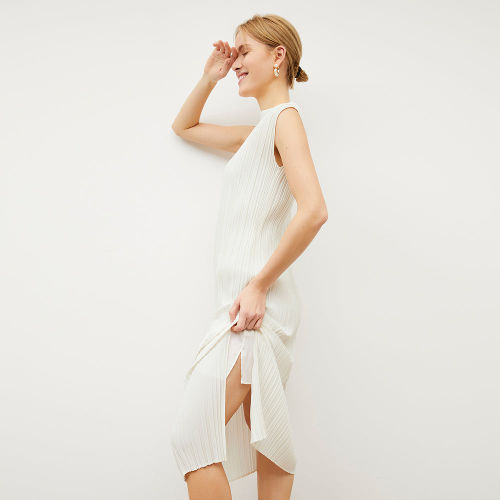 Side image of a woman wearing the Edith Dress - Micro Pleat in Ivory
