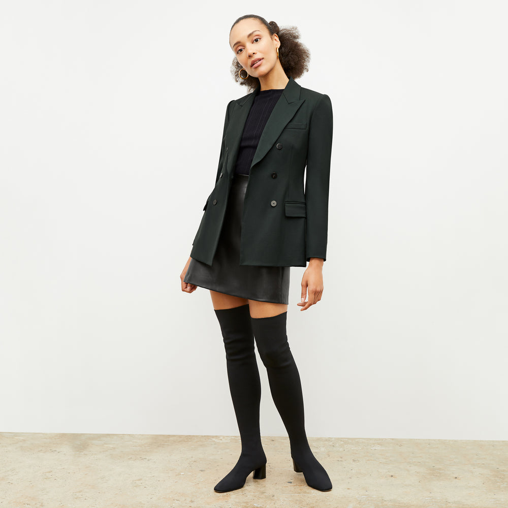 Front image of a woman standing wearing the Whitney Skit—Vegan Leather in Black