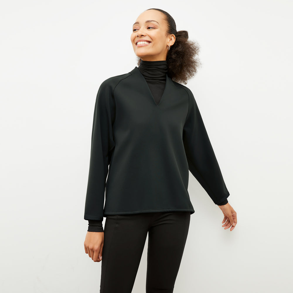Front image of a woman wearing the shawn sweatshirt in forest
