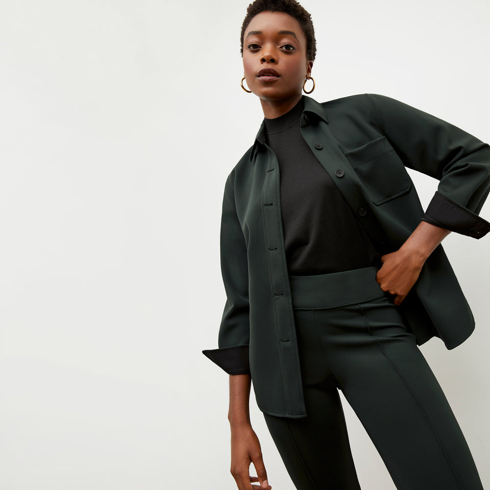 Front image of a woman wearing the sierra shacket in forest