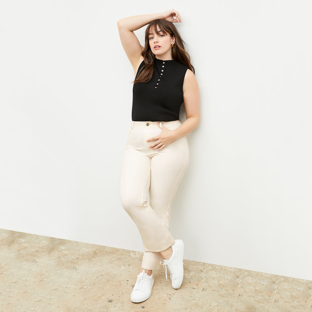 Front image of a woman standing wearing the malki top in black
