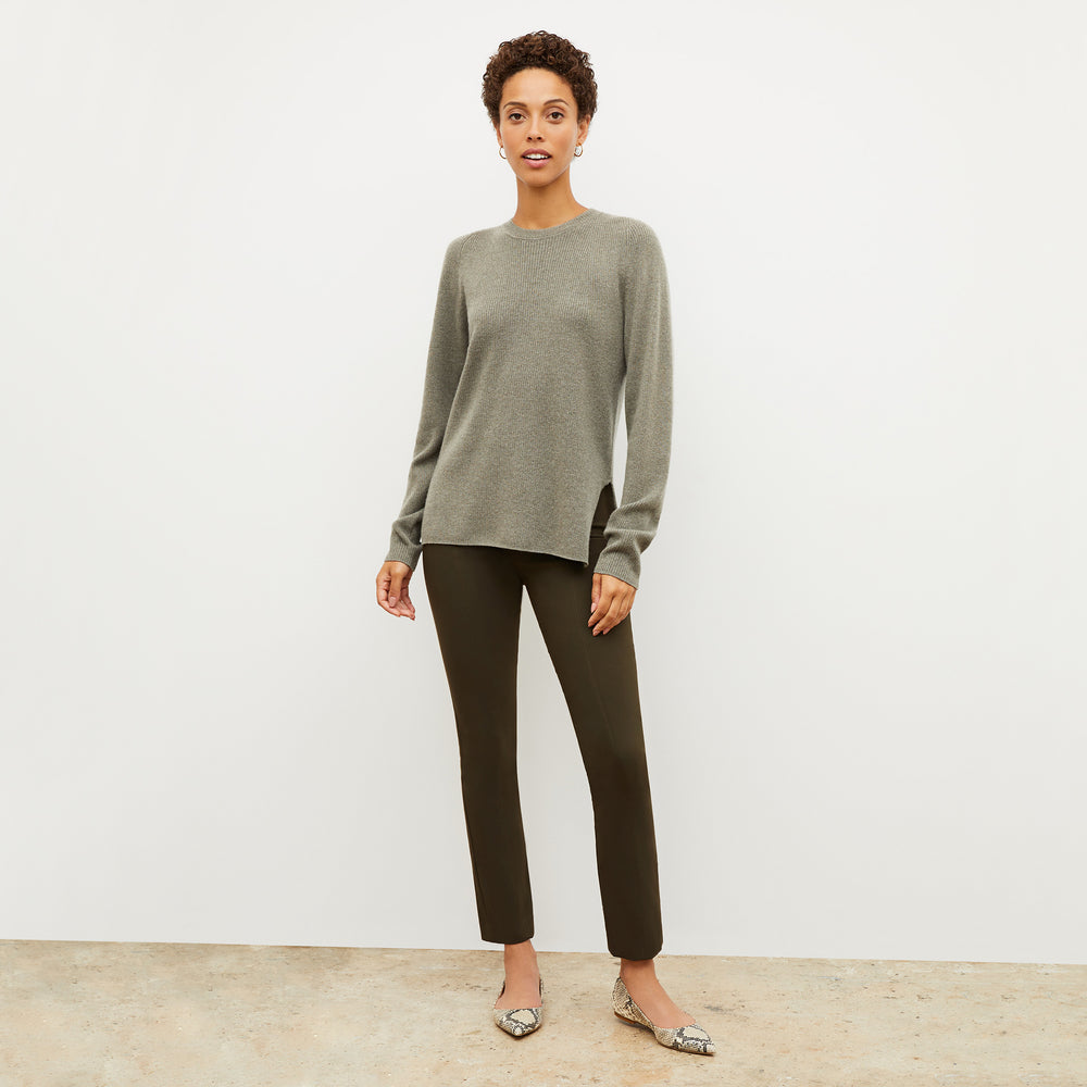 Front image of a woman wearing the ollie sweater in dark moss