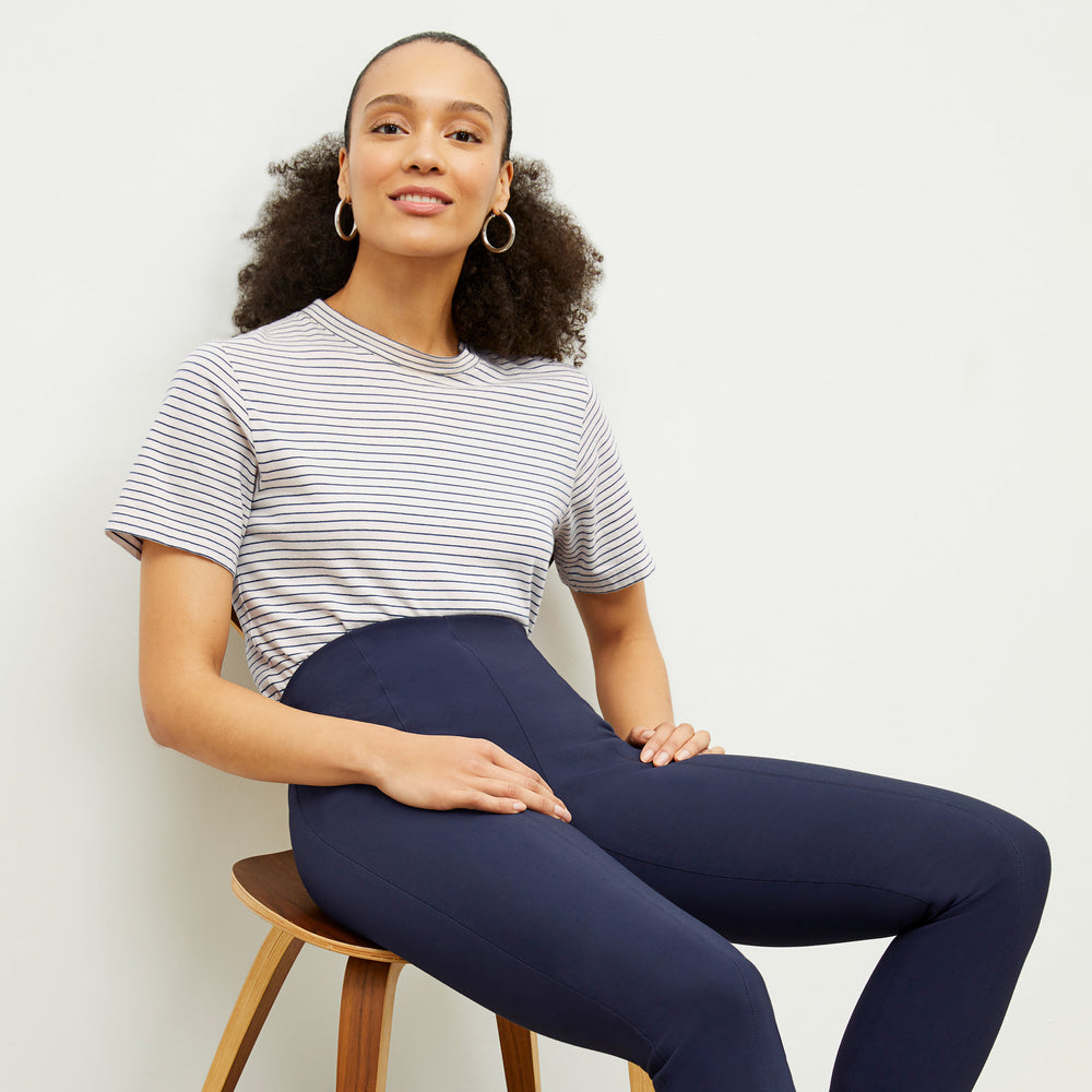 Front image of a woman standing wearing the Leslie T-Shirt—Thin Striped Cotton in Ivory / Coastline