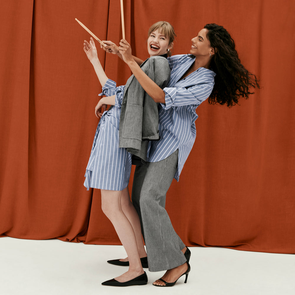 front image of a woman wearing the Nichols shirt in blue and white poplin stripe