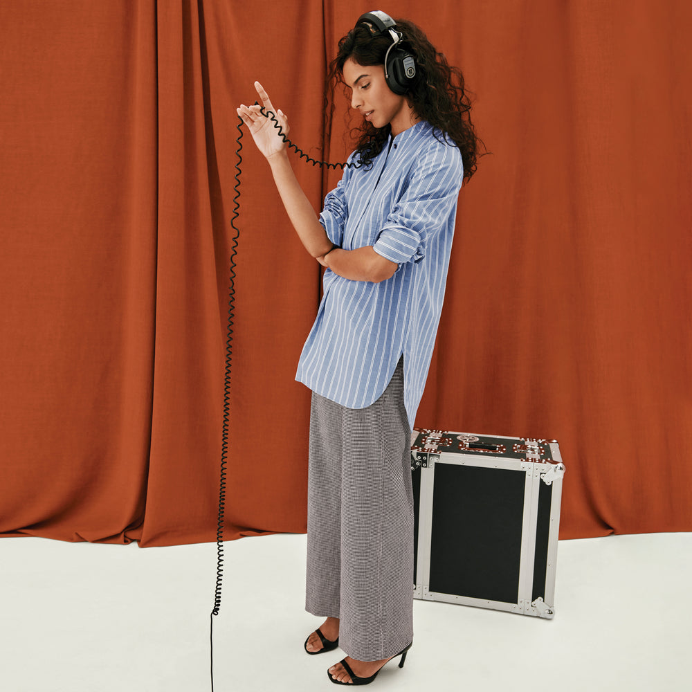 front image of a woman wearing the Nichols shirt in blue and white poplin stripe