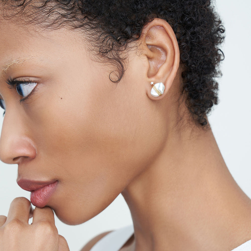 Detail image of a woman standing wearing the Amari Earrings in Gold