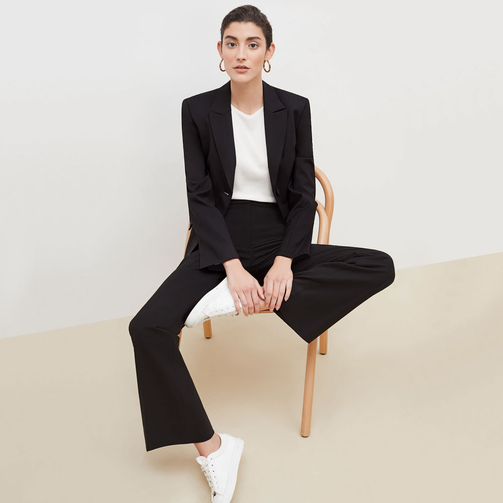 Front image of a woman sitting wearing the bennett blazer wool twill in black