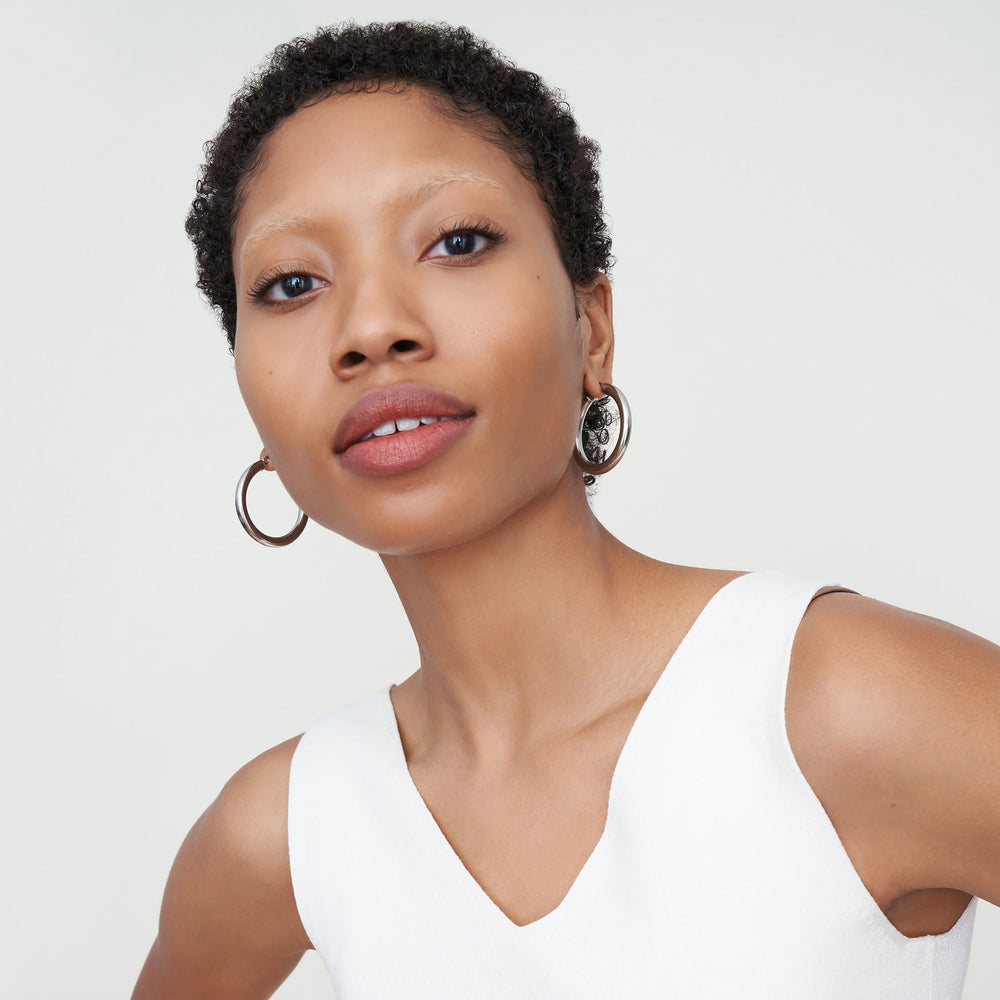 Detail image of a woman standing wearing the Claressa Earrrings Medium in Silver