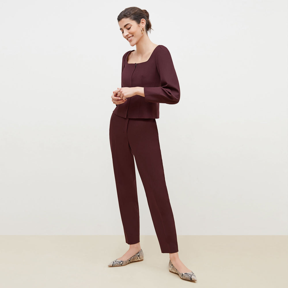 Side image of a woman standing wearing the Dawn Top-Sharkskin in garnet