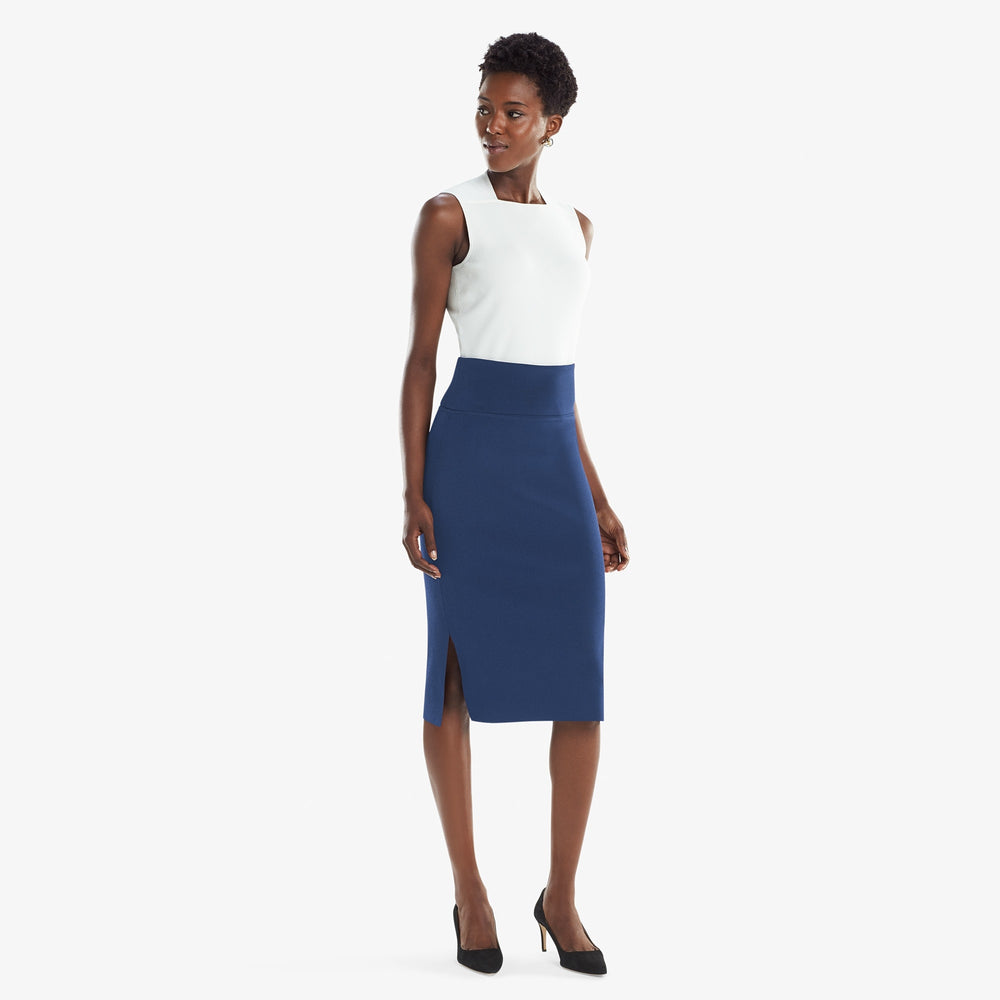 Front image of a woman standing wearing the Harlem skirt in Regent blue