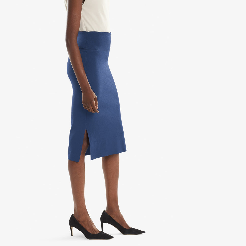 Side image of a woman standing wearing the Harlem skirt in Regent blue
