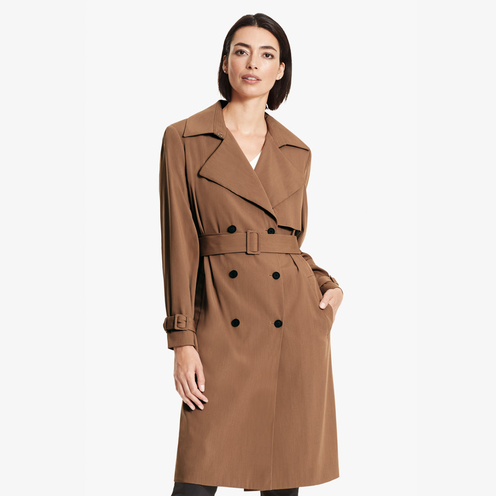 Front image of a woman standing wearing the Jensen trench in Saddle