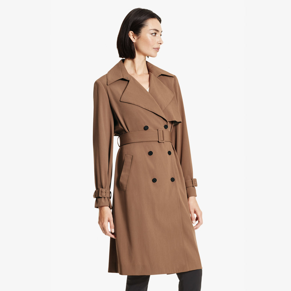 Front image of a woman standing wearing the Jensen trench in Saddle