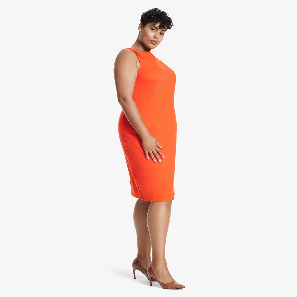 Side image of a woman standing wearing the Lydia dress textured ponte in Tangerine