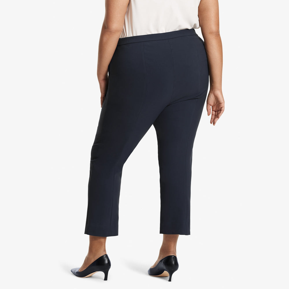 Back image of a woman standing wearing the Oshima pant in Dark navy