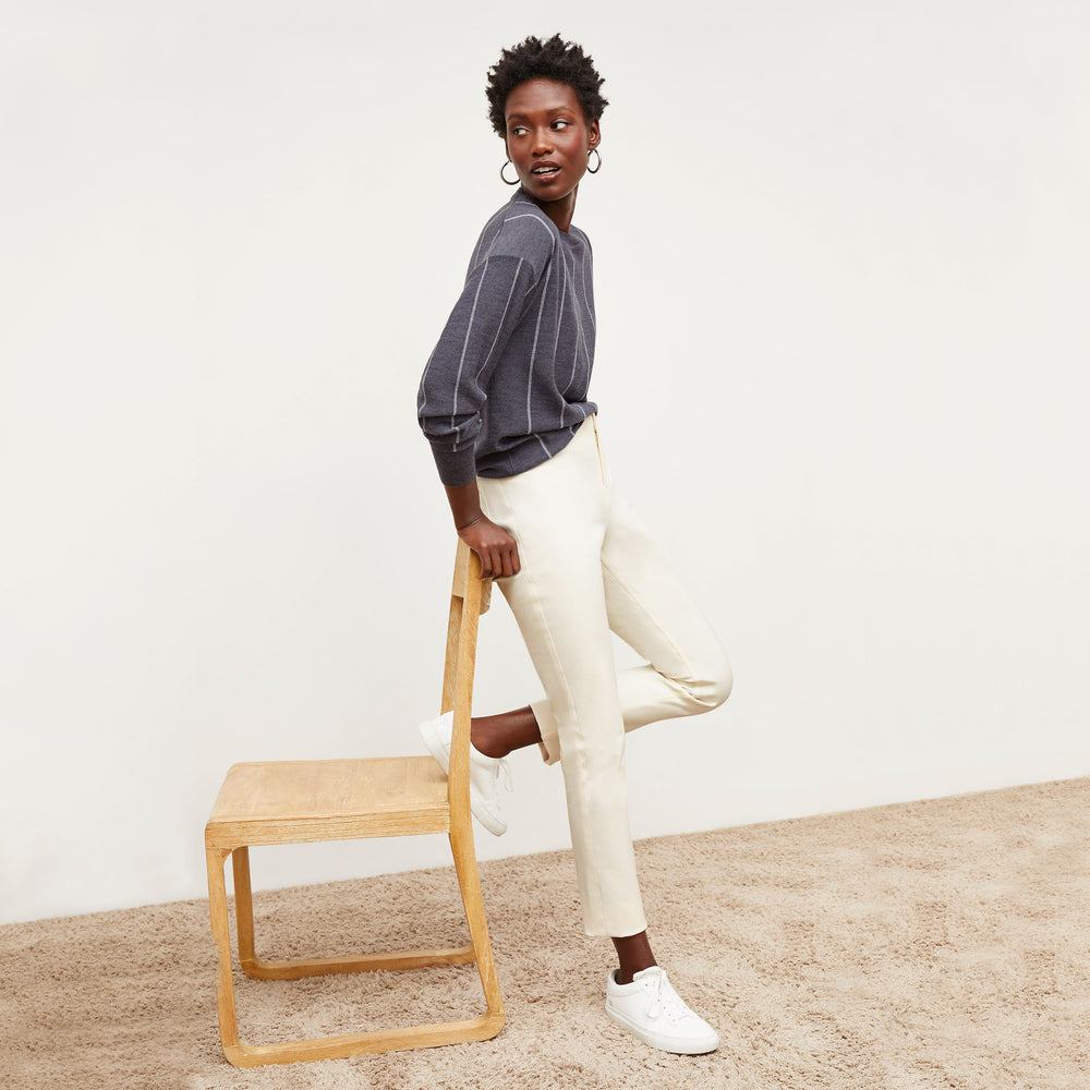 Side image of a woman standing wearing the Ingola Sweater—Braided Stripe in Charcoal / Ivory
