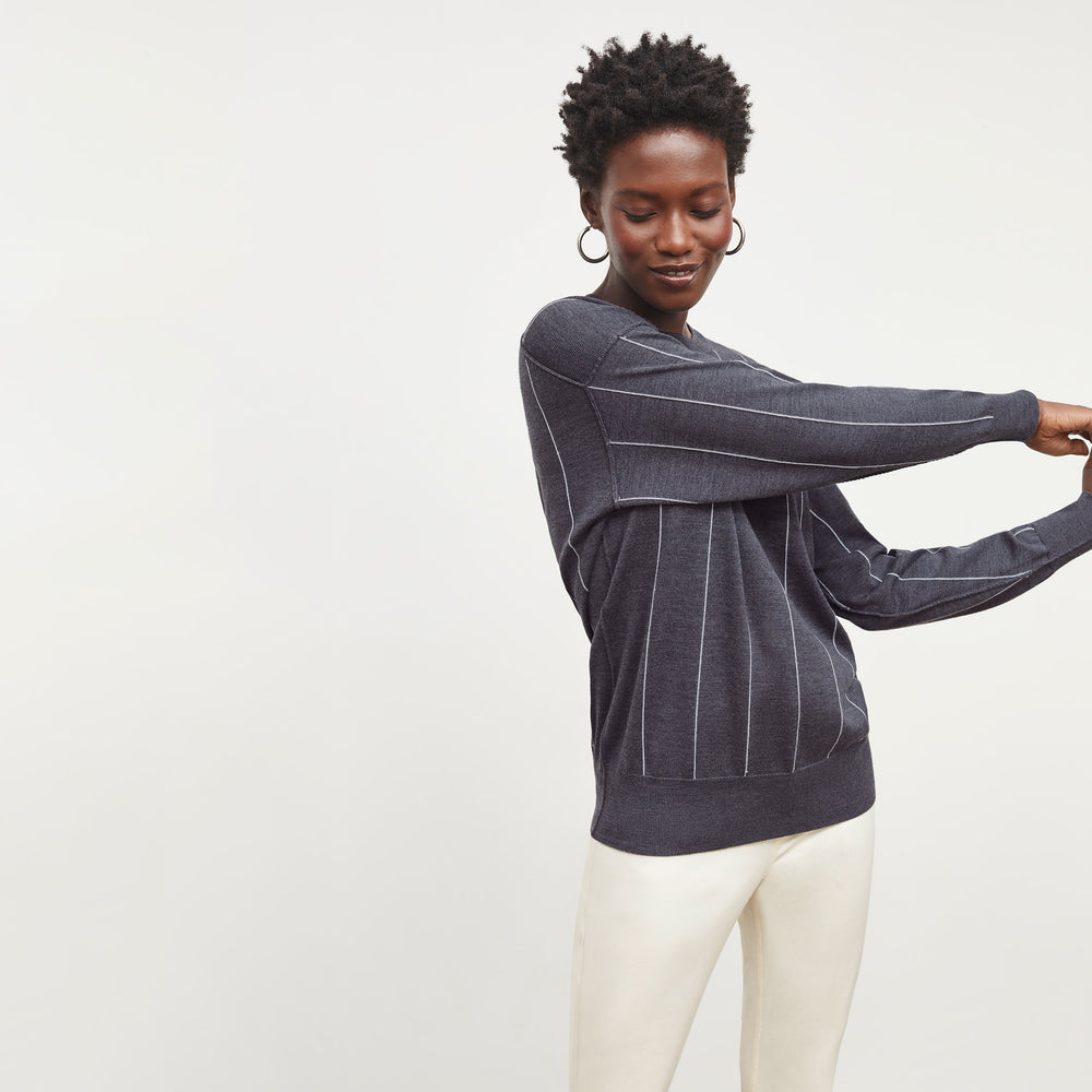 Front image of a woman standing wearing the Ingola Sweater—Braided Stripe in Charcoal / Ivory